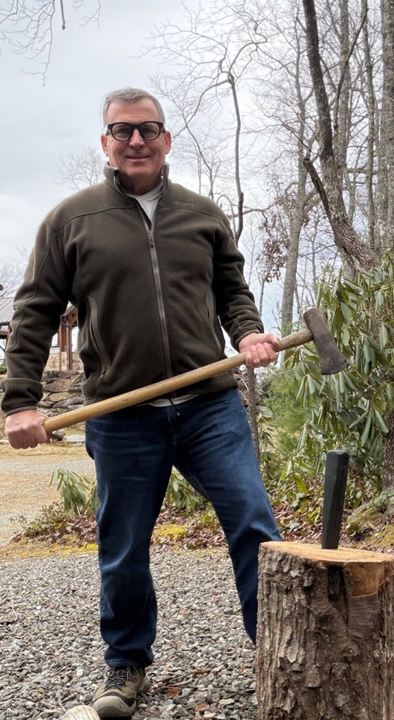 Scott Adams chopping wood while wearing Meta glasses.